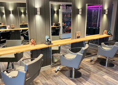 Elegant salon interior at Pearce and Chapman Hair and Beauty, Beddau, Wales, GB with modern styling chairs and mirrors.