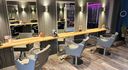 Elegant salon interior at Pearce and Chapman Hair and Beauty, Beddau, Wales, GB with modern styling chairs and mirrors.