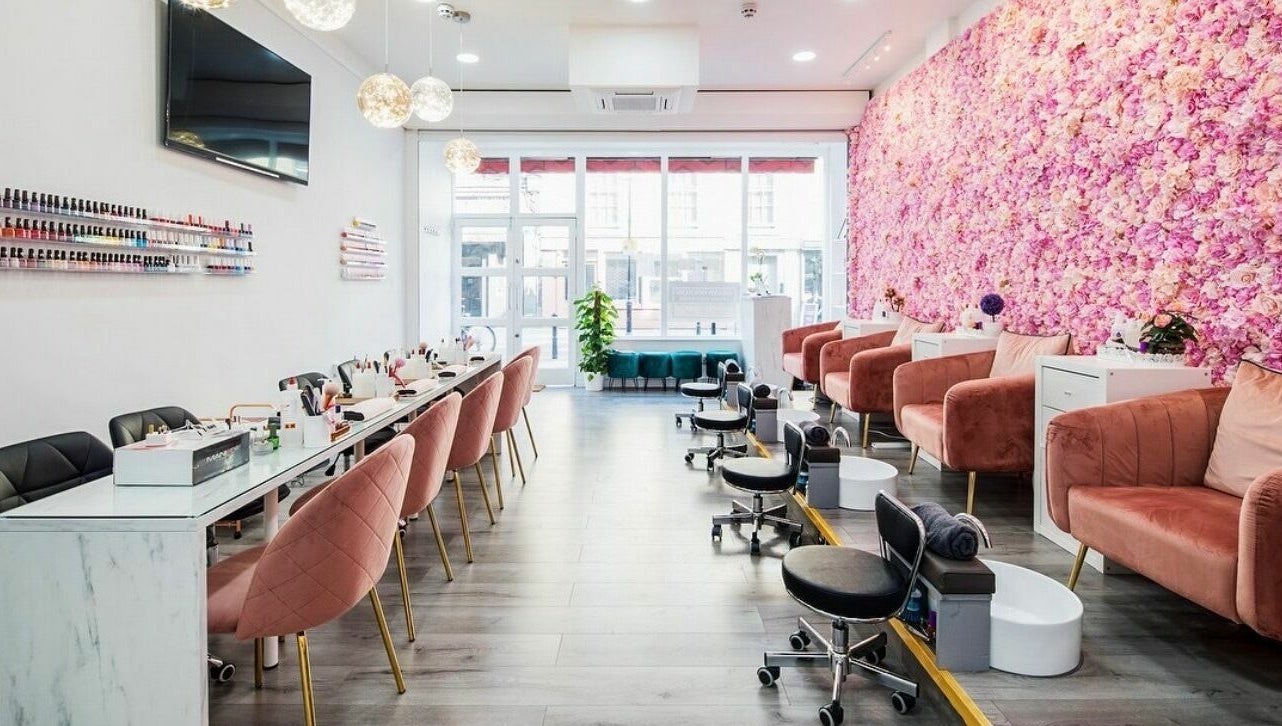 Belle Ame Beauty Champagne Lounge in London, England, GB, features elegant seating with a floral wall accent.