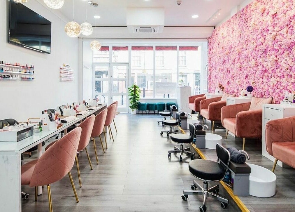 Belle Ame Beauty Champagne Lounge in London, England, GB, features elegant seating with a floral wall accent.