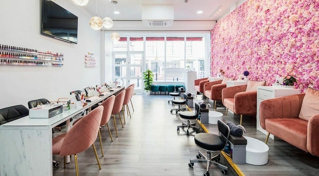 Belle Ame Beauty Champagne Lounge in London, England, GB, features elegant seating with a floral wall accent.