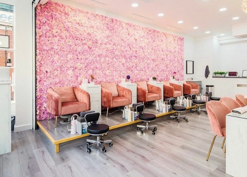 Luxurious seating area with pink floral wall at Belle Ame Beauty Champagne Lounge, London, England, GB.