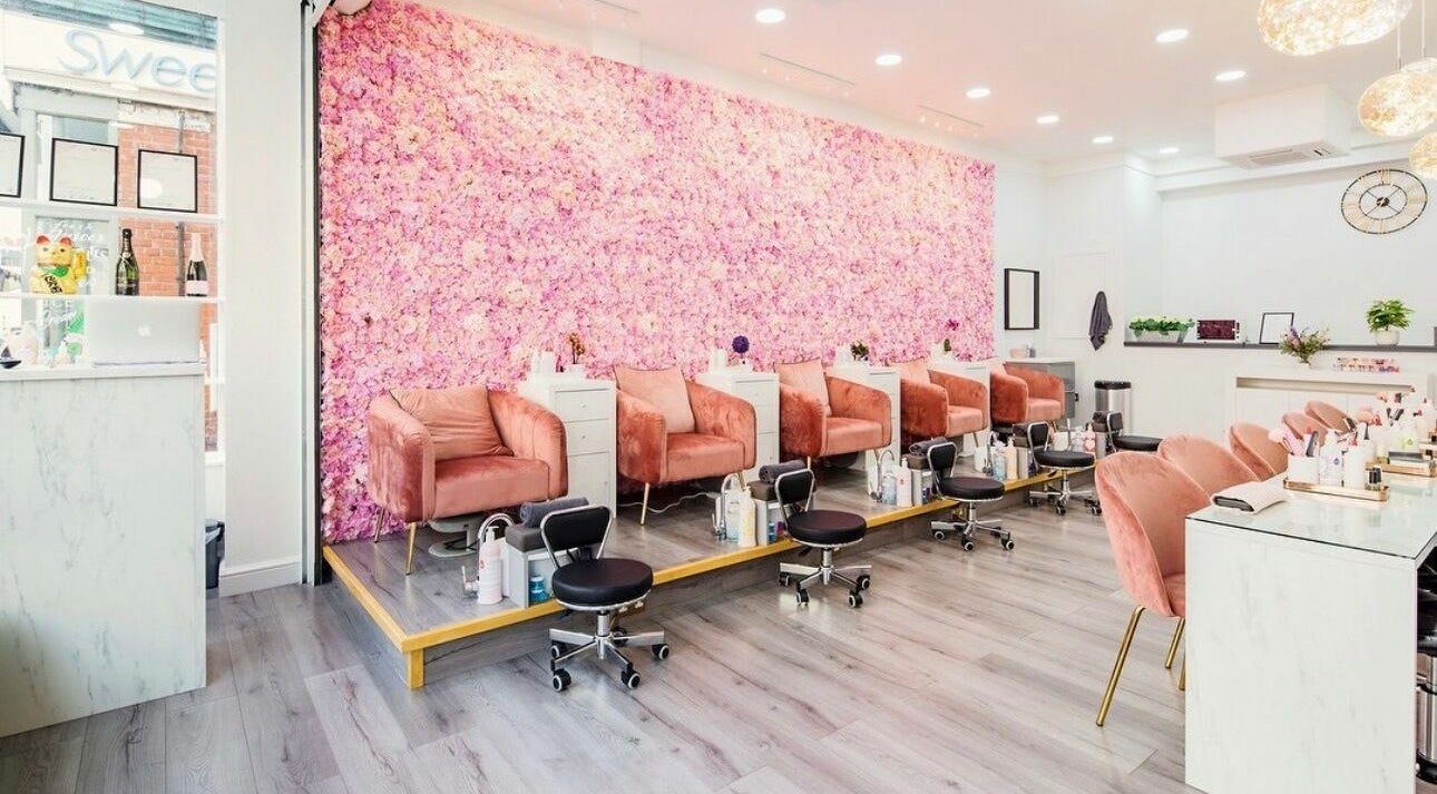 Luxurious seating area with pink floral wall at Belle Ame Beauty Champagne Lounge, London, England, GB.