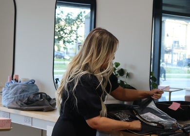 Stylist preparing hair tools at Fika Beauty East in Ottawa, Ontario, CA, offering premium beauty services.
