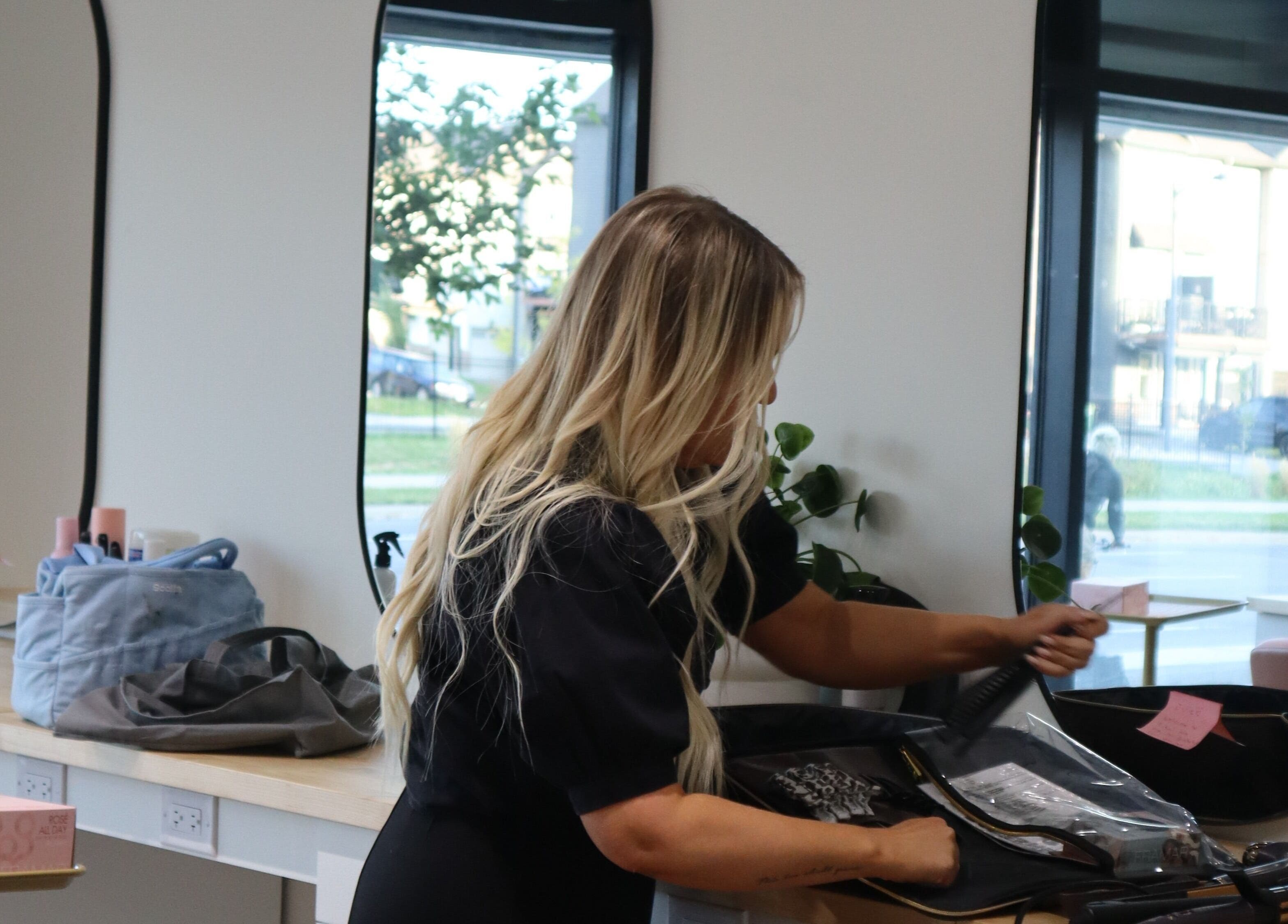 Stylist preparing hair tools at Fika Beauty East in Ottawa, Ontario, CA, offering premium beauty services.