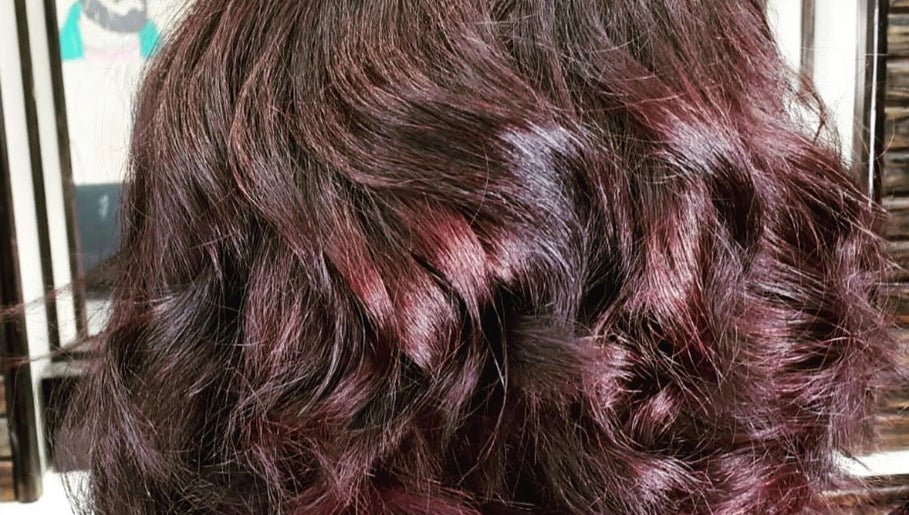 Rich auburn wavy hair styled at Monica Mobil hairdresser, London, GB.