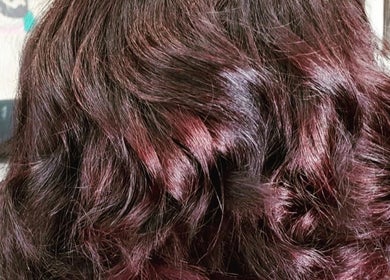 Rich auburn wavy hair styled at Monica Mobil hairdresser, London, GB.