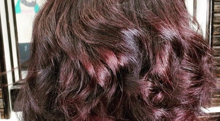 Rich auburn wavy hair styled at Monica Mobil hairdresser, London, GB.