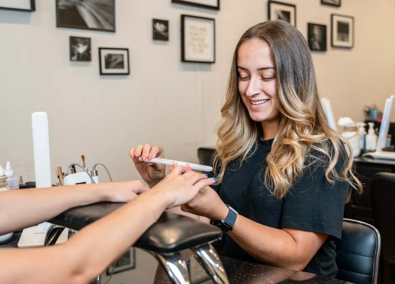 Nail technician at Onyx Nail Bar in Voorhees Township giving a manicure with a smile.