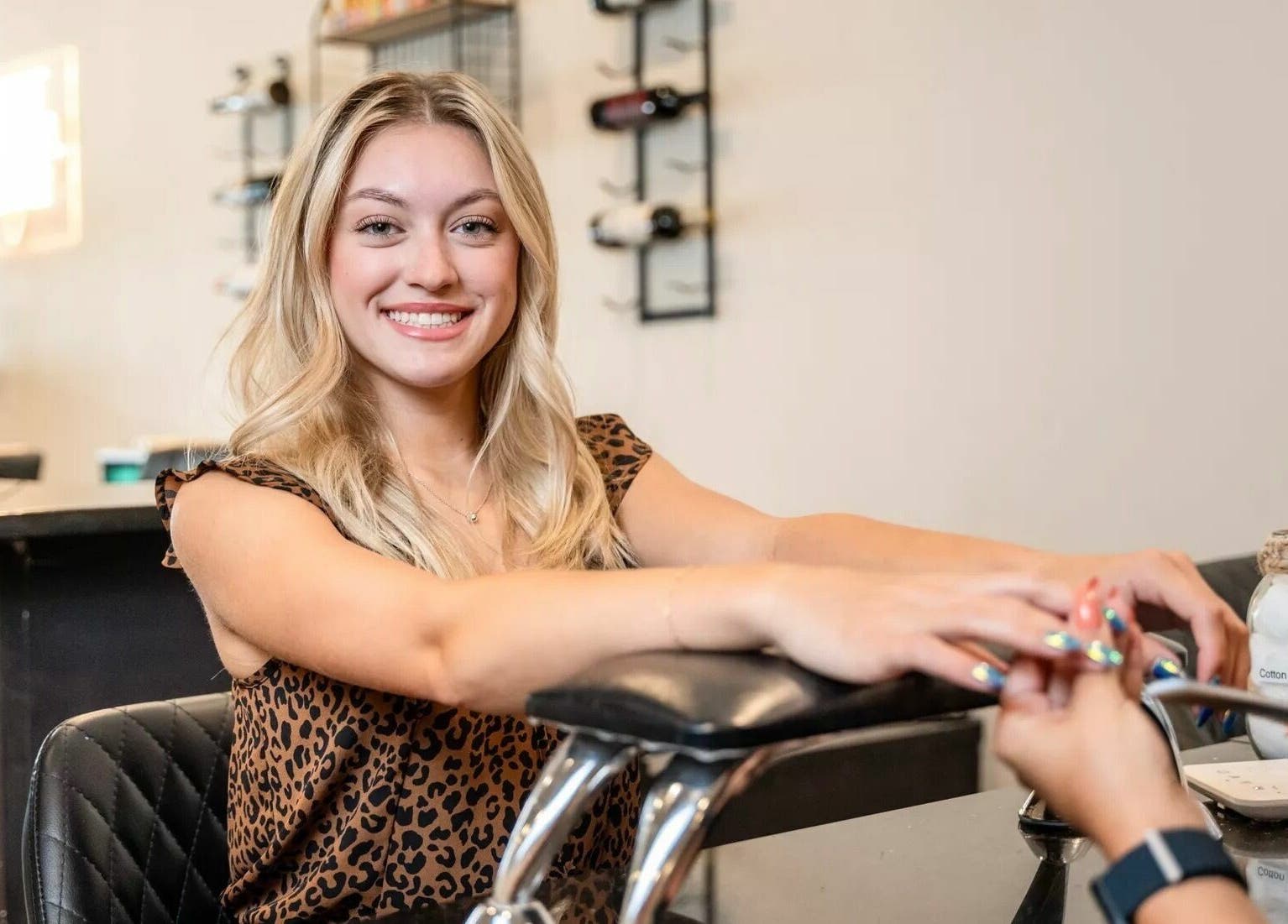 Woman receiving a colorful manicure at Onyx Nail Bar, Voorhees Township, New Jersey, US, smiling happily.