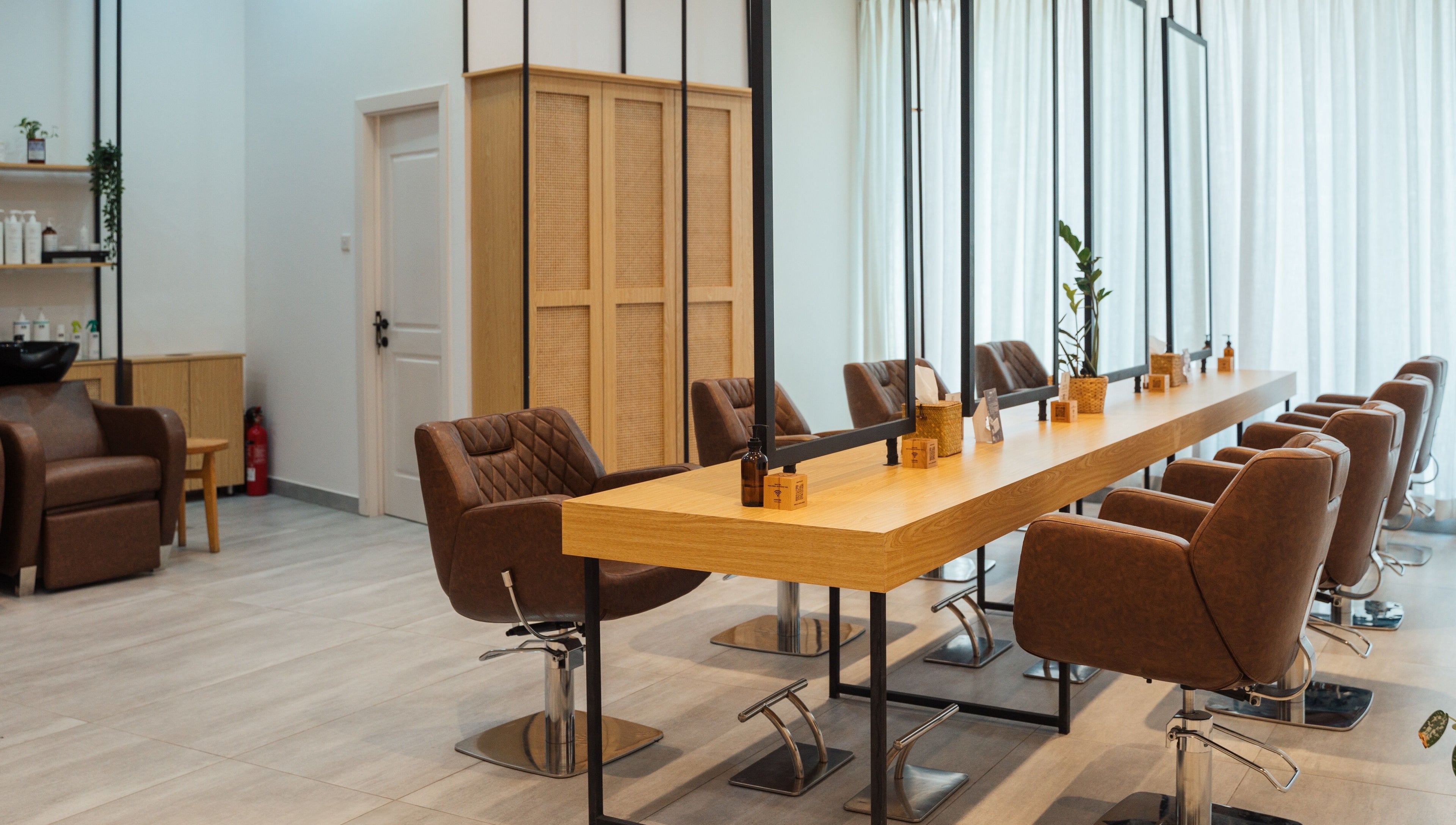 Elegant interior of Boho Salon AD in Abu Dhabi, showcasing modern chairs and mirrors in a welcoming atmosphere.