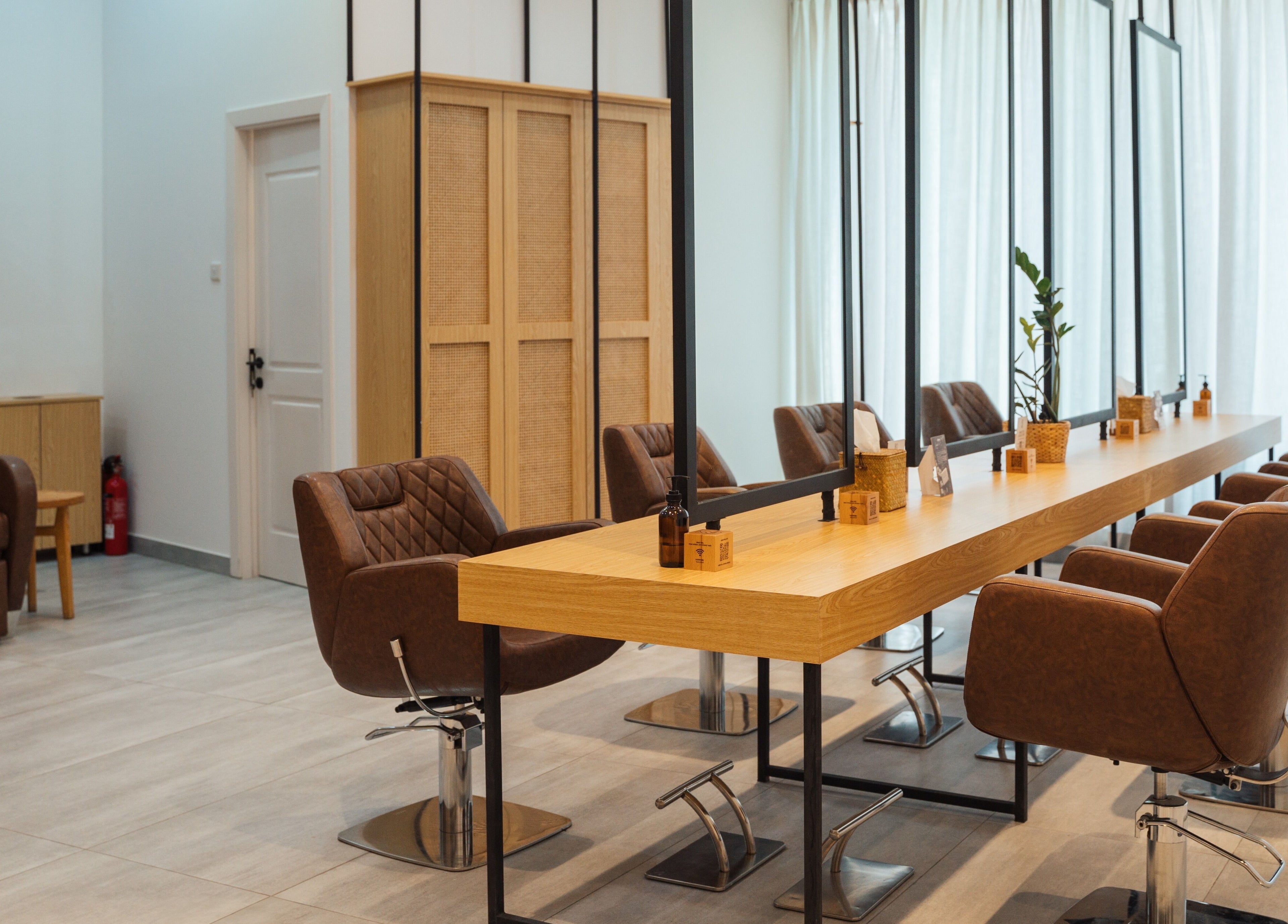 Elegant interior of Boho Salon AD in Abu Dhabi, showcasing modern chairs and mirrors in a welcoming atmosphere.
