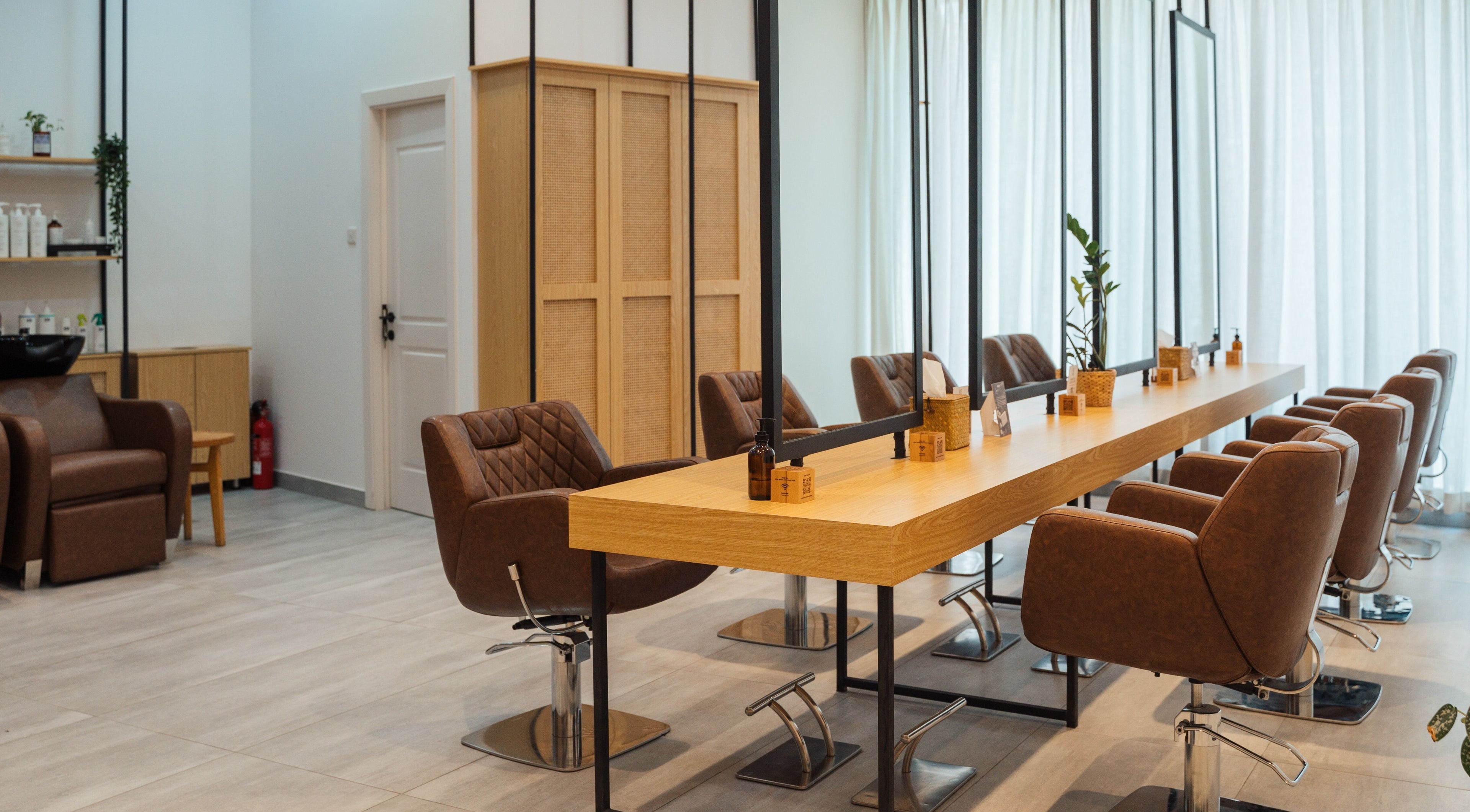 Elegant interior of Boho Salon AD in Abu Dhabi, showcasing modern chairs and mirrors in a welcoming atmosphere.