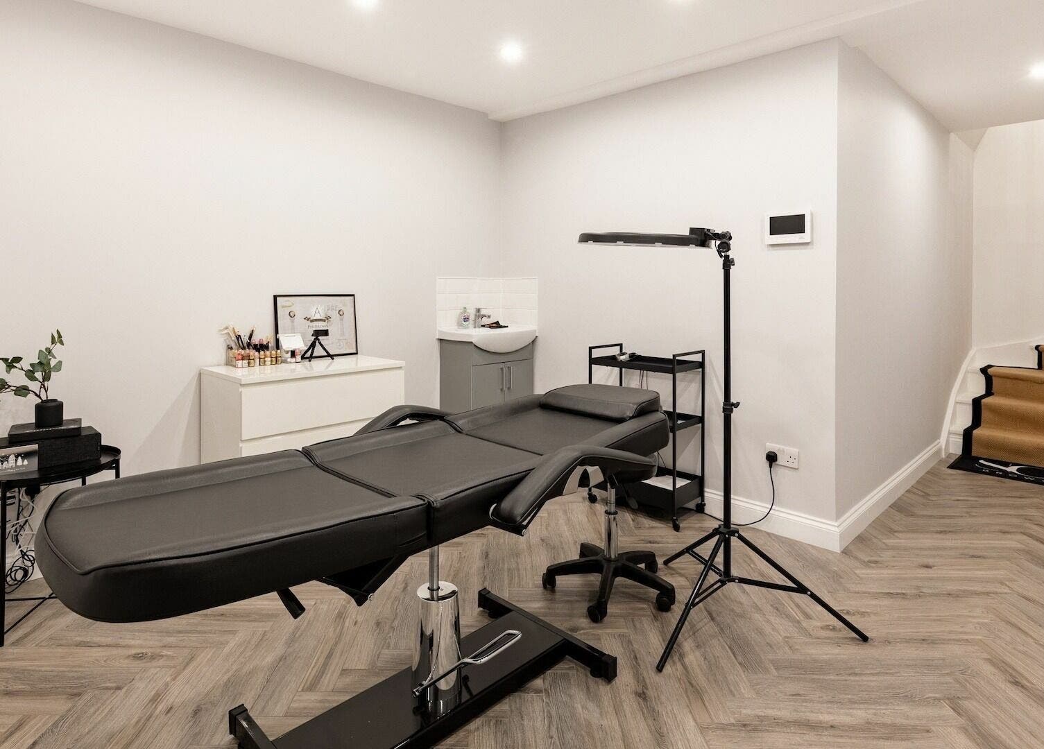 Modern treatment room at SO Brows, London, England, GB with sleek decor and a comfortable beauty bed.