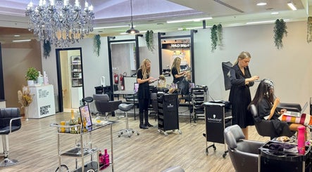 Stylish interior of Salon 971 in Dubai, AE, featuring luxury chandeliers and professional hairstylists at work.