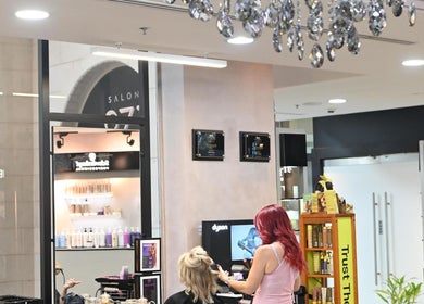 Inside Salon 971 in Dubai, Dubai, AE, featuring a stylist working on a client's hair under elegant lighting.