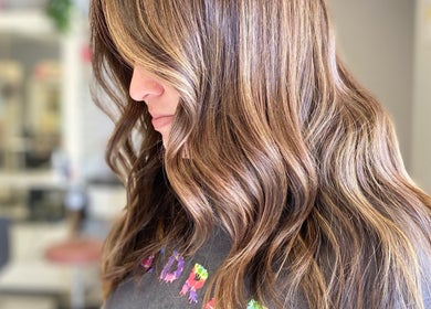 Brunette hair with golden highlights styled in waves at Bridget Nottingham Hair Design, Huntington Beach, California, US.