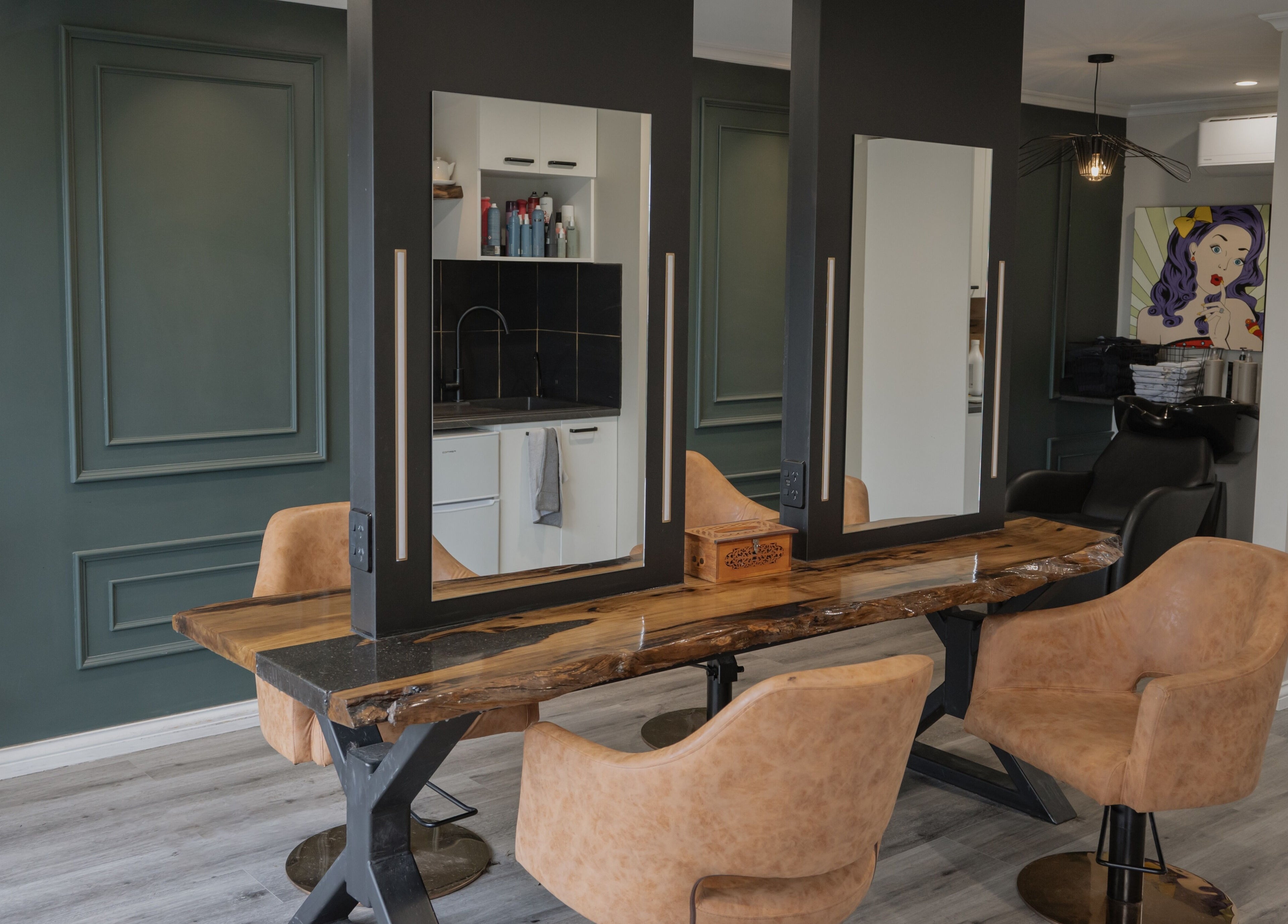 Stylish salon interior at Scarlet Hair Studio, Tauranga, Bay of Plenty, NZ with wooden table and modern chairs.
