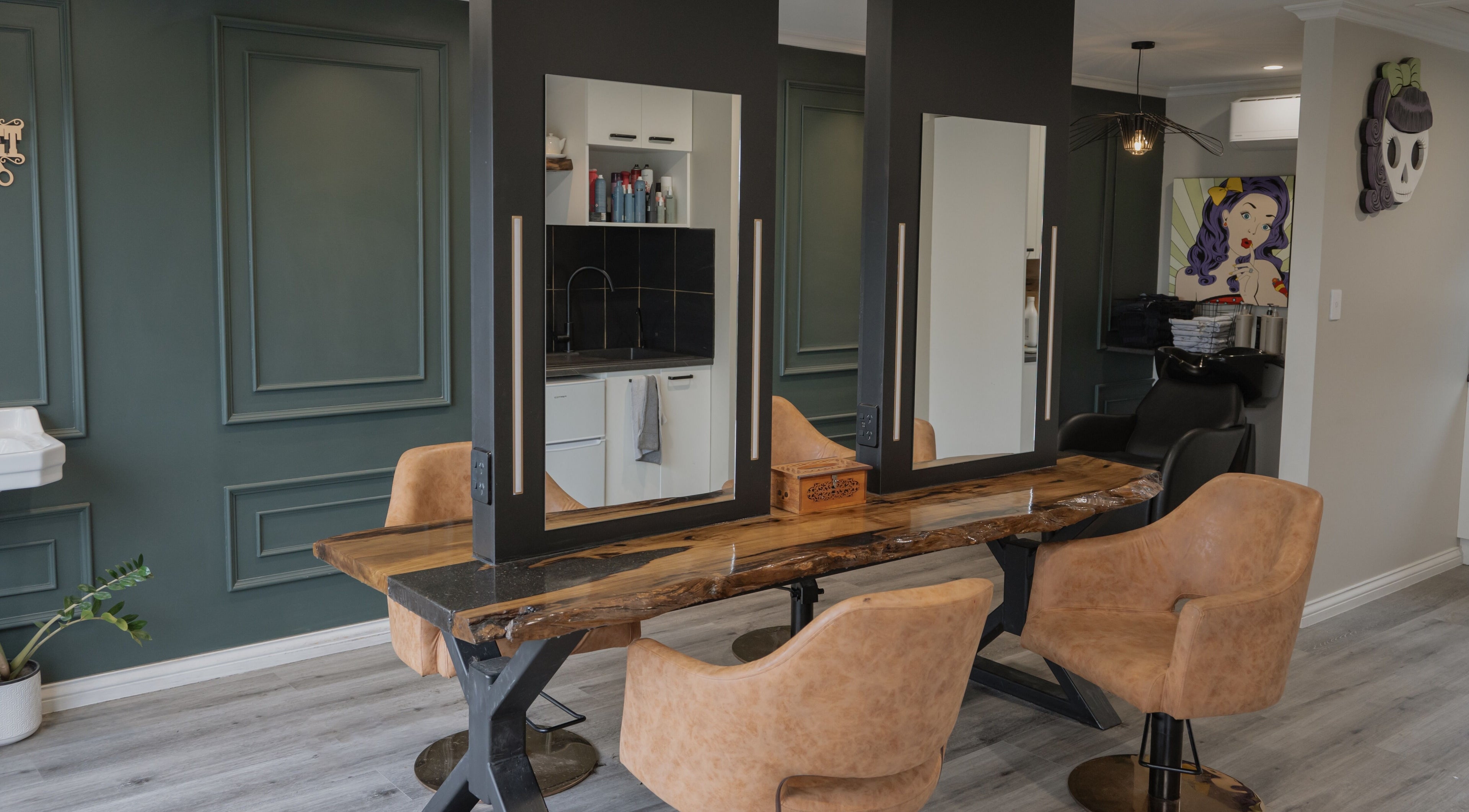 Stylish salon interior at Scarlet Hair Studio, Tauranga, Bay of Plenty, NZ with wooden table and modern chairs.
