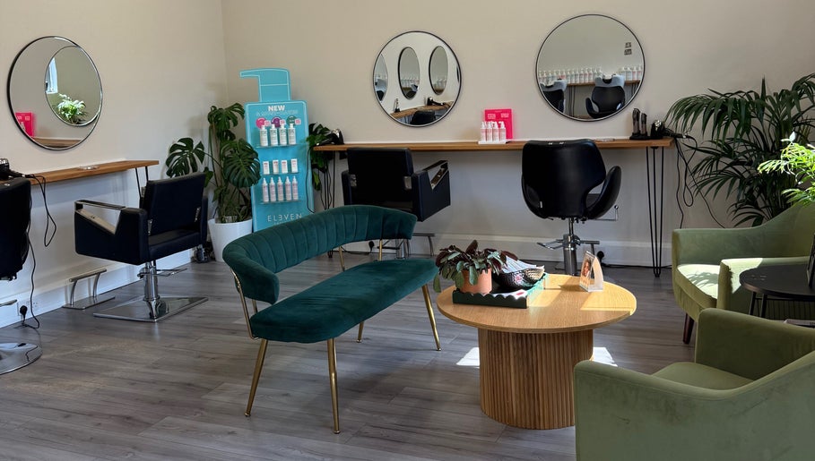 Elegant salon interior at Willow Hair and Wellbeing, Woodbury, England, GB, featuring modern seating and mirrors.