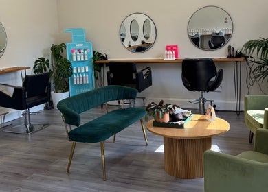 Elegant salon interior at Willow Hair and Wellbeing, Woodbury, England, GB, featuring modern seating and mirrors.