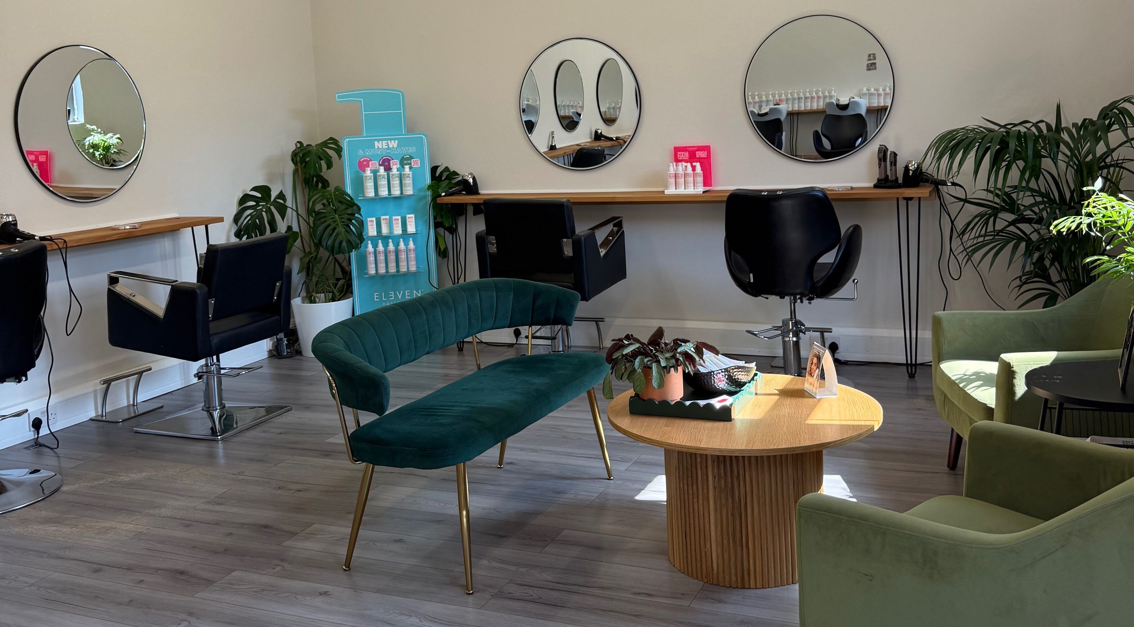Elegant salon interior at Willow Hair and Wellbeing, Woodbury, England, GB, featuring modern seating and mirrors.
