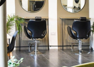 Modern salon chairs at Willow Hair and Wellbeing in Woodbury, England, GB surrounded by plants.