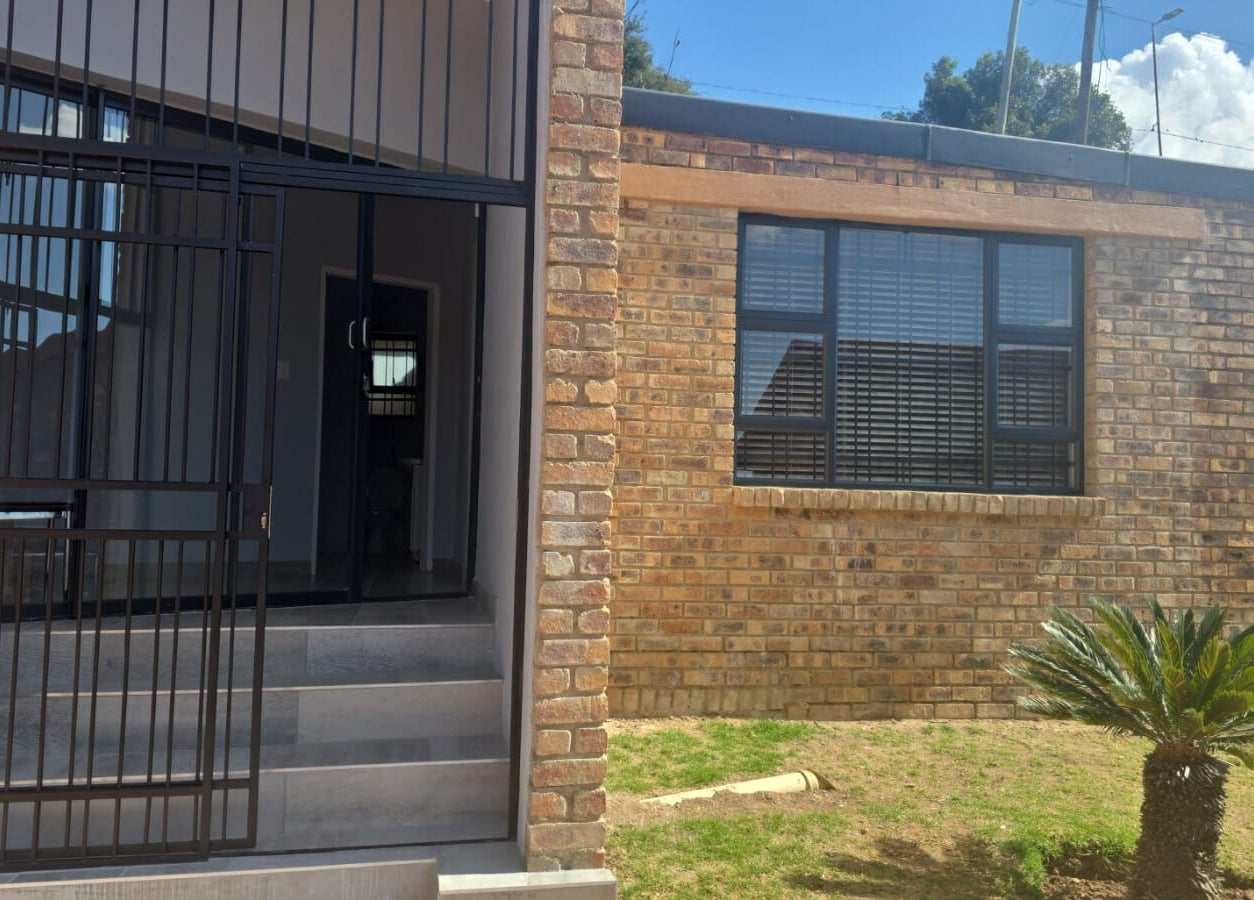 Front entrance of Studio A - Skin Aesthetics in Roodepoort, Gauteng, ZA with brick facade and glass door.