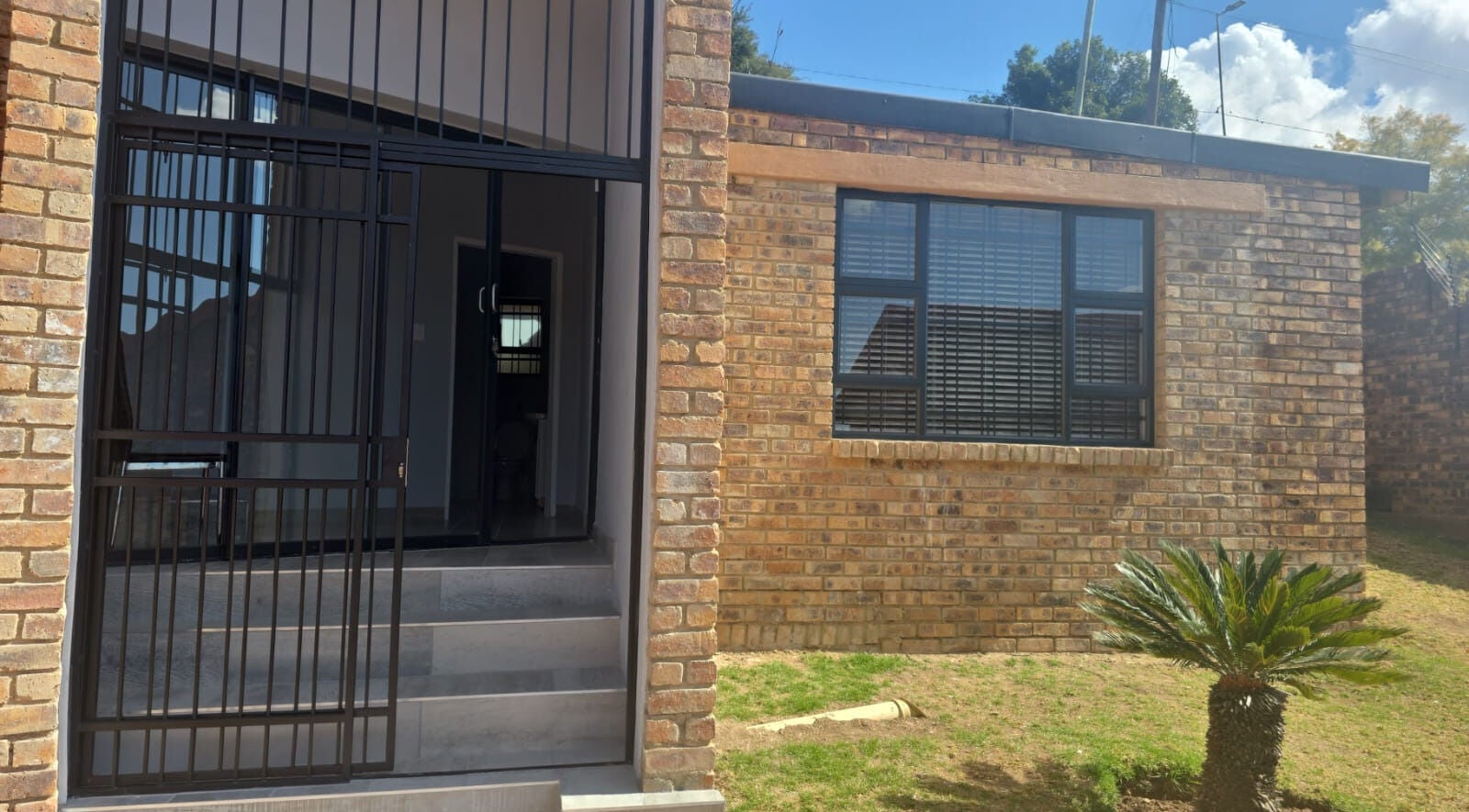 Front entrance of Studio A - Skin Aesthetics in Roodepoort, Gauteng, ZA with brick facade and glass door.