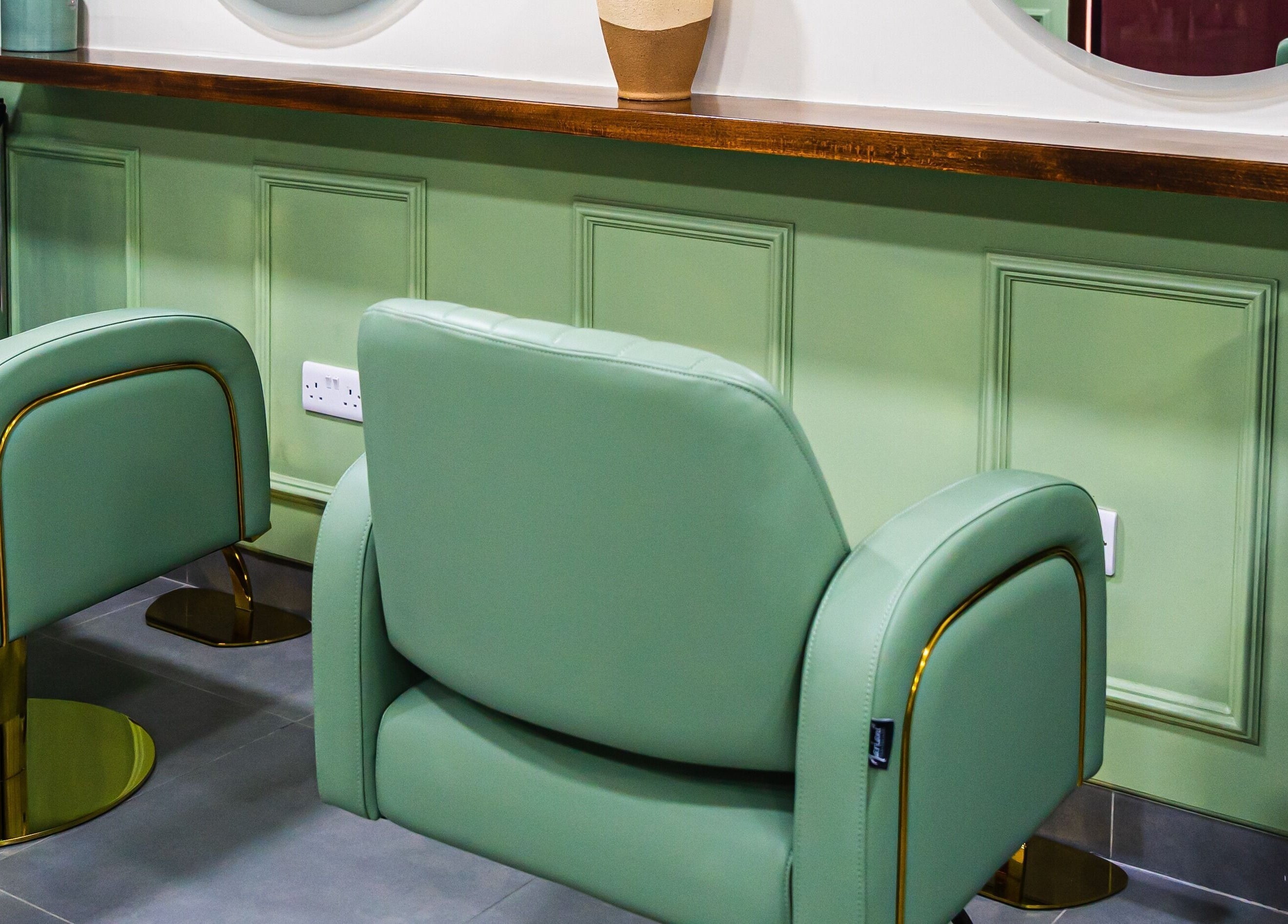Stylish green salon chairs at Wandies Hair and Beauty Salon in Sharjah, AE, showcasing comfort and luxury.
