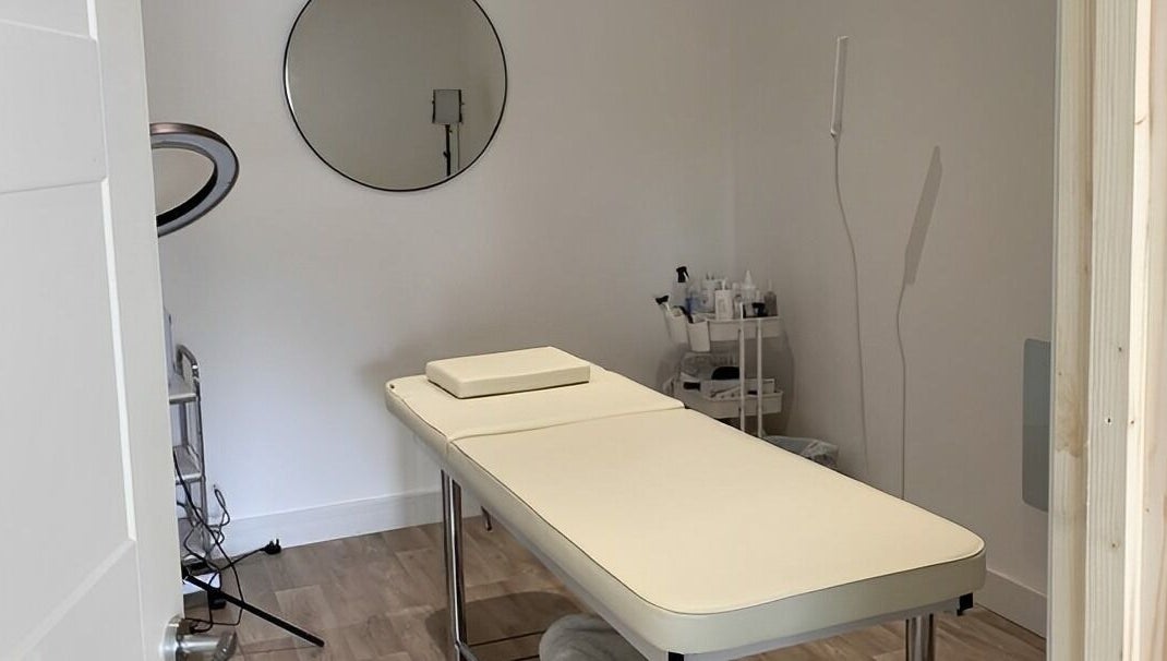 Serene treatment room at Belle's Boutique in East Grinstead, England, GB, featuring a massage table and decor.