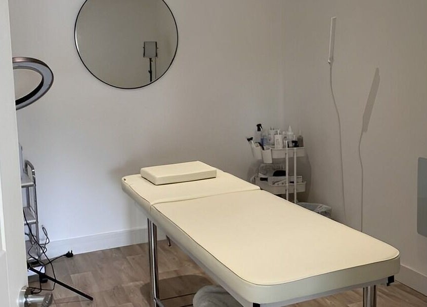 Serene treatment room at Belle's Boutique in East Grinstead, England, GB, featuring a massage table and decor.