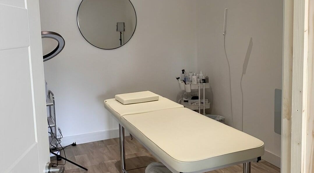 Serene treatment room at Belle's Boutique in East Grinstead, England, GB, featuring a massage table and decor.