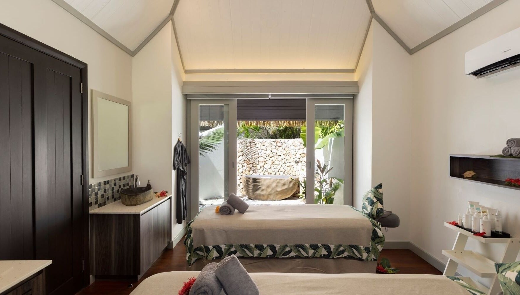 Serene spa room at Sofitel Fiji Resort & Spa on Denarau Island, showcasing elegant decor and garden view.