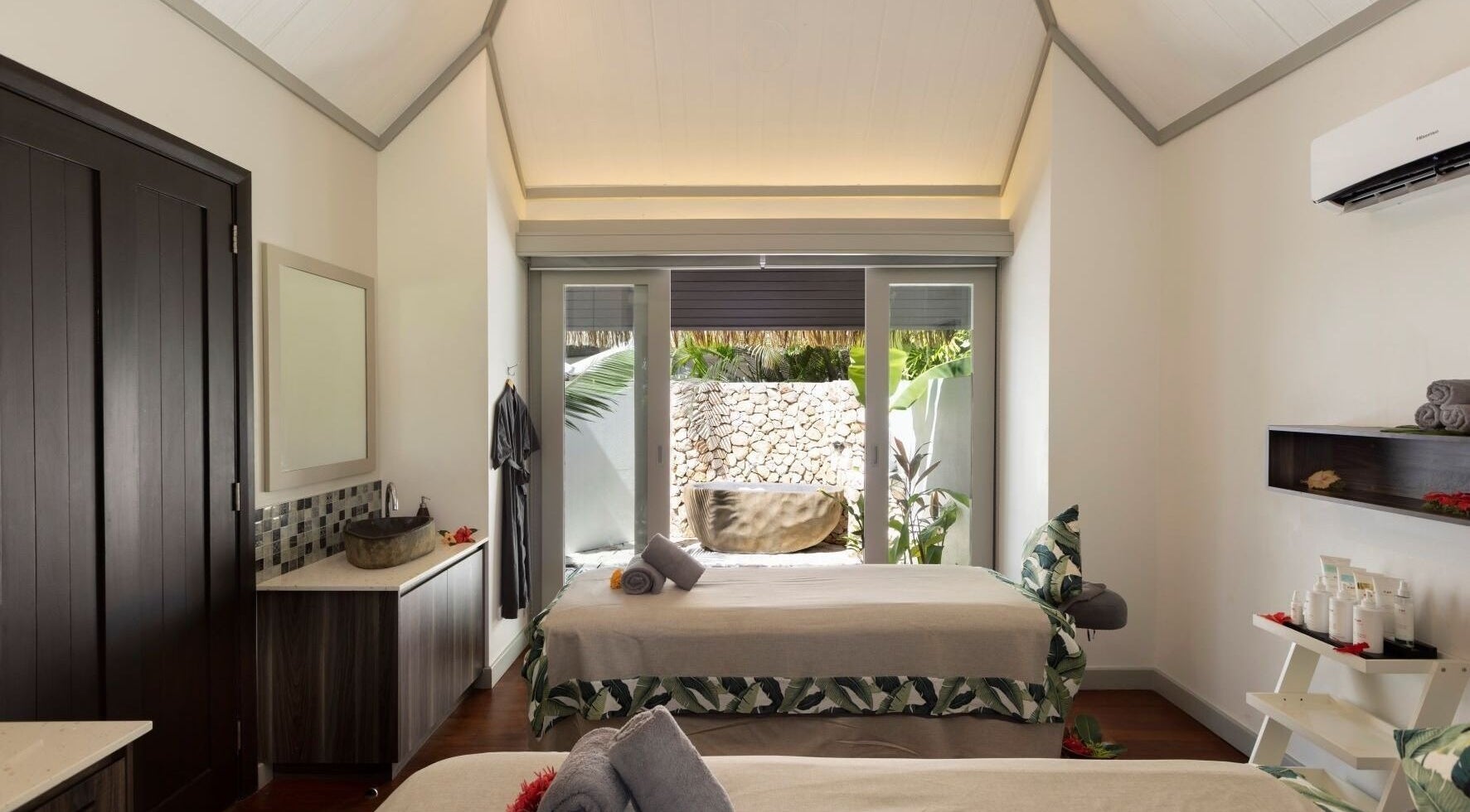 Serene spa room at Sofitel Fiji Resort & Spa on Denarau Island, showcasing elegant decor and garden view.