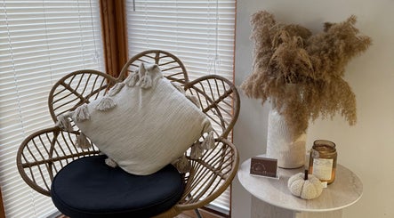 Tranquil seating area at Beauty by Chloe, Hopton, England, GB with wicker chair and decor.