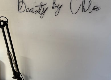 Elegant wall sign at Beauty by Chloe, Hopton, England, GB with modern lamp and products.