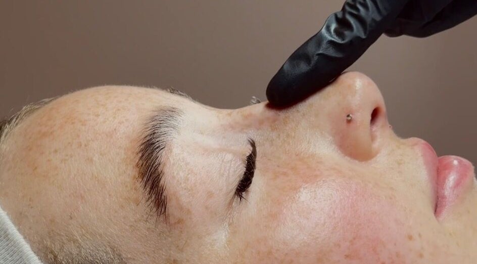 Relaxing facial at Face by Demi in Hook, England, GB with gentle black-gloved touch.