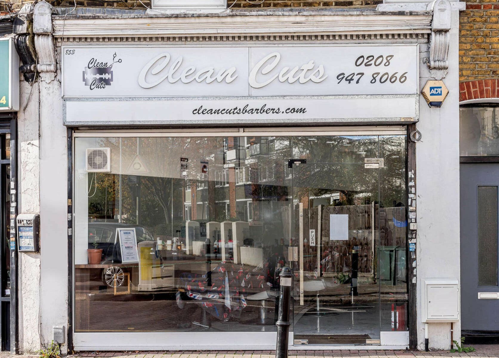 Front view of Clean Cuts London barber shop in London, England, GB with large display windows.