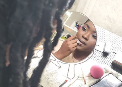 Woman applying makeup at The Finished Look Rodney Bay, Rodney Heights, St. Lucia, JM.