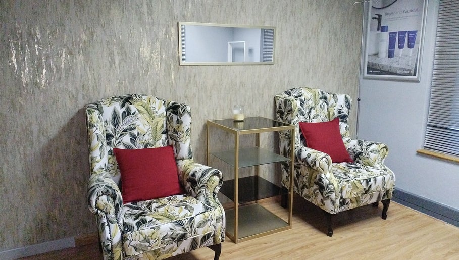 Elegant lounge at Lin-Glazed Beauty, Centurion, Gauteng, ZA with floral armchairs and red cushions.
