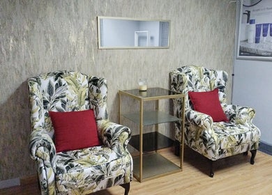 Elegant lounge at Lin-Glazed Beauty, Centurion, Gauteng, ZA with floral armchairs and red cushions.