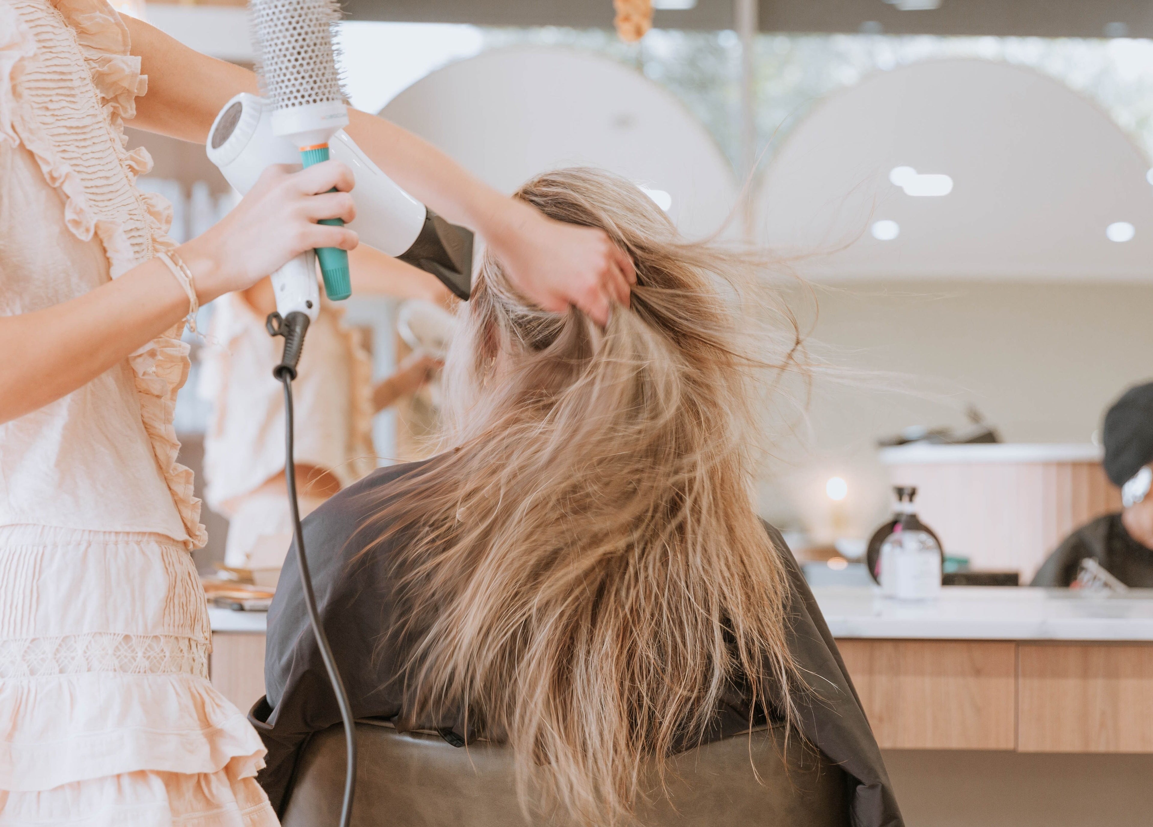 Stylist performing a blowout at Beauty and The Fox, Merewether, New South Wales, AU. Luxurious beauty experience.