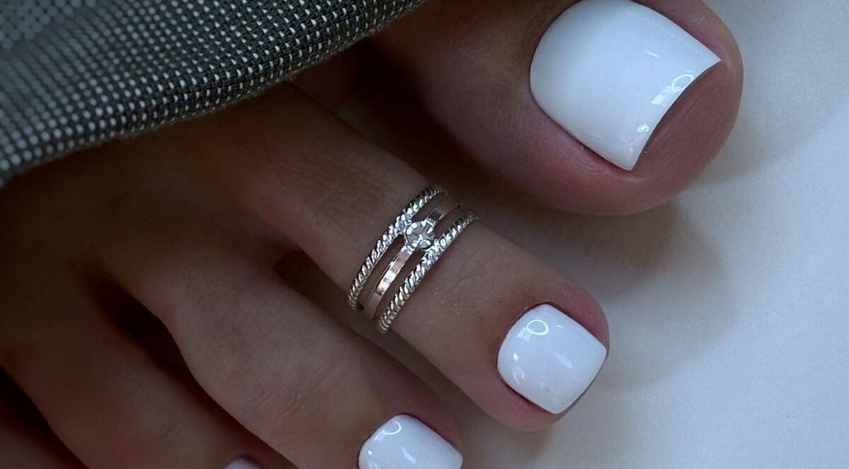 Chic white pedicure with rings at Lux Artistry, Cape Town, Western Cape, ZA showcasing elegance.