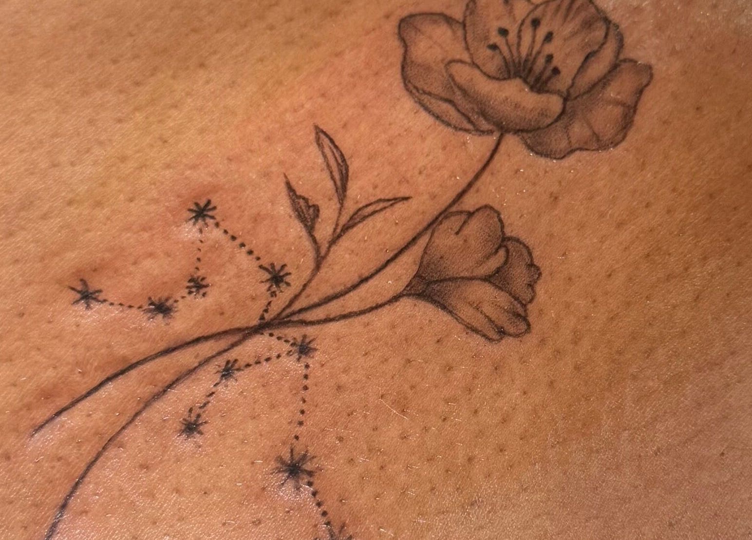 Delicate floral tattoo at Serenity Aesthetic Clinic, Kempston, England, GB, showcasing expert artistry.