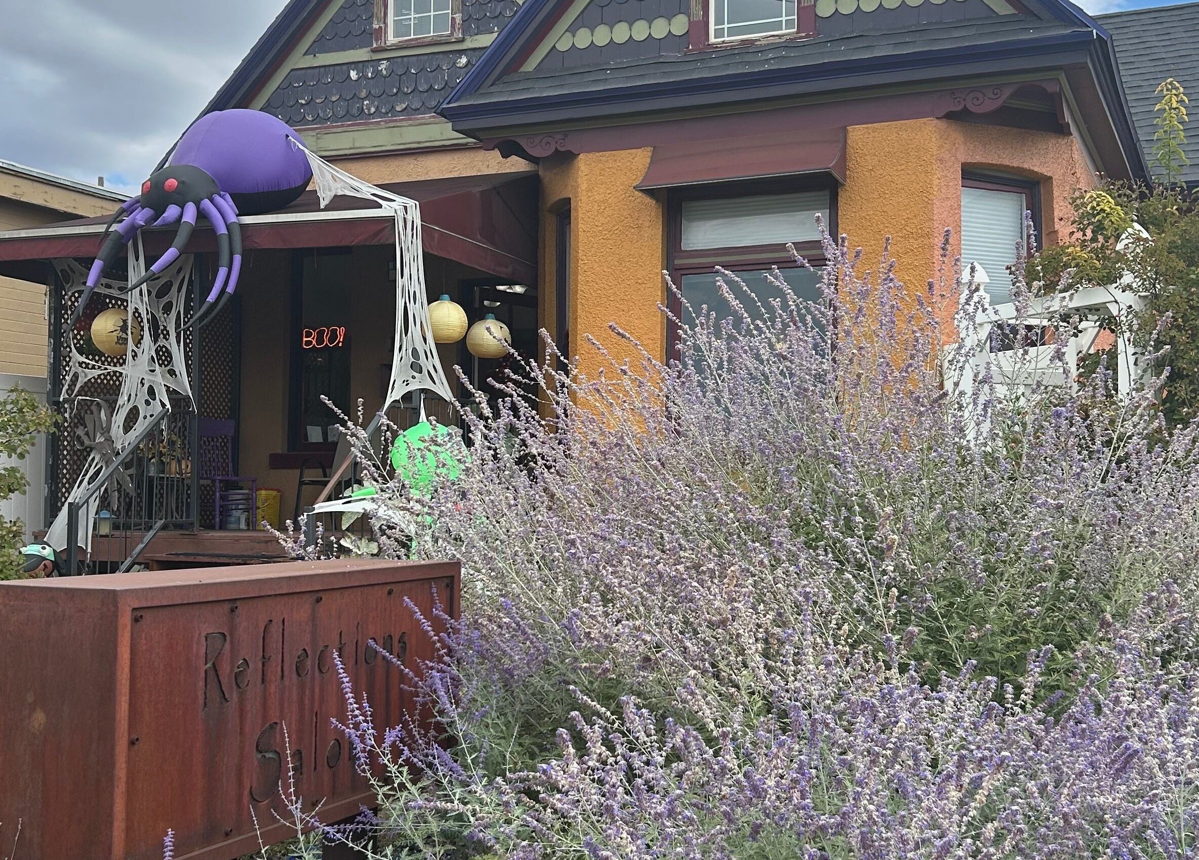 Charming exterior of Reflections Salon and Spa in Salt Lake City, Utah with festive decor and lush lavender.
