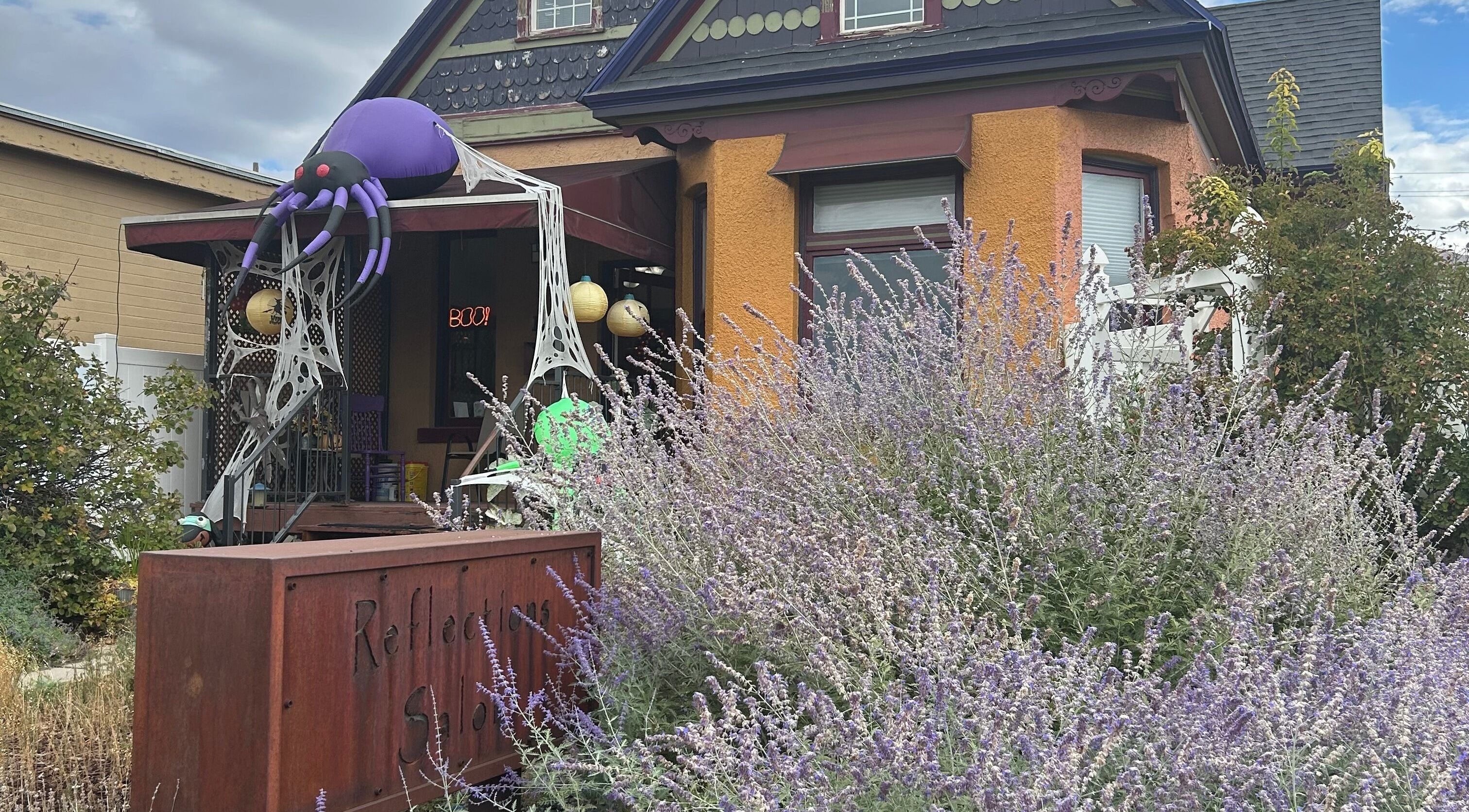 Charming exterior of Reflections Salon and Spa in Salt Lake City, Utah with festive decor and lush lavender.