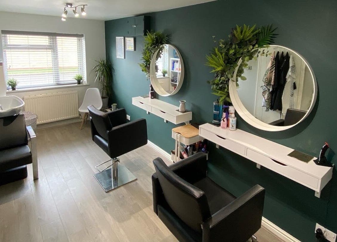 Modern salon interior at Laura Fuller Freelance Stylist, Evesham, England, GB, featuring stylish chairs and mirrors.