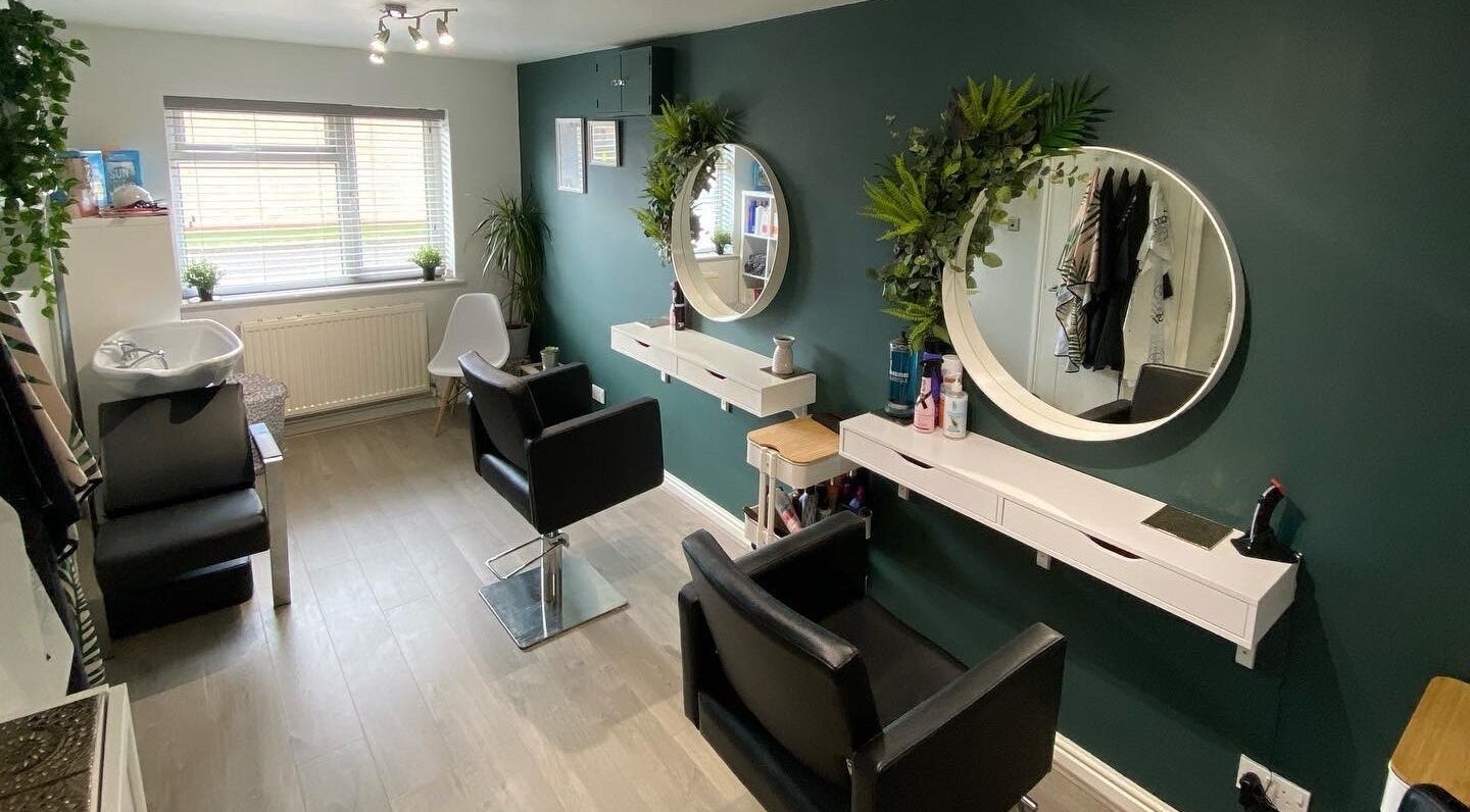 Modern salon interior at Laura Fuller Freelance Stylist, Evesham, England, GB, featuring stylish chairs and mirrors.