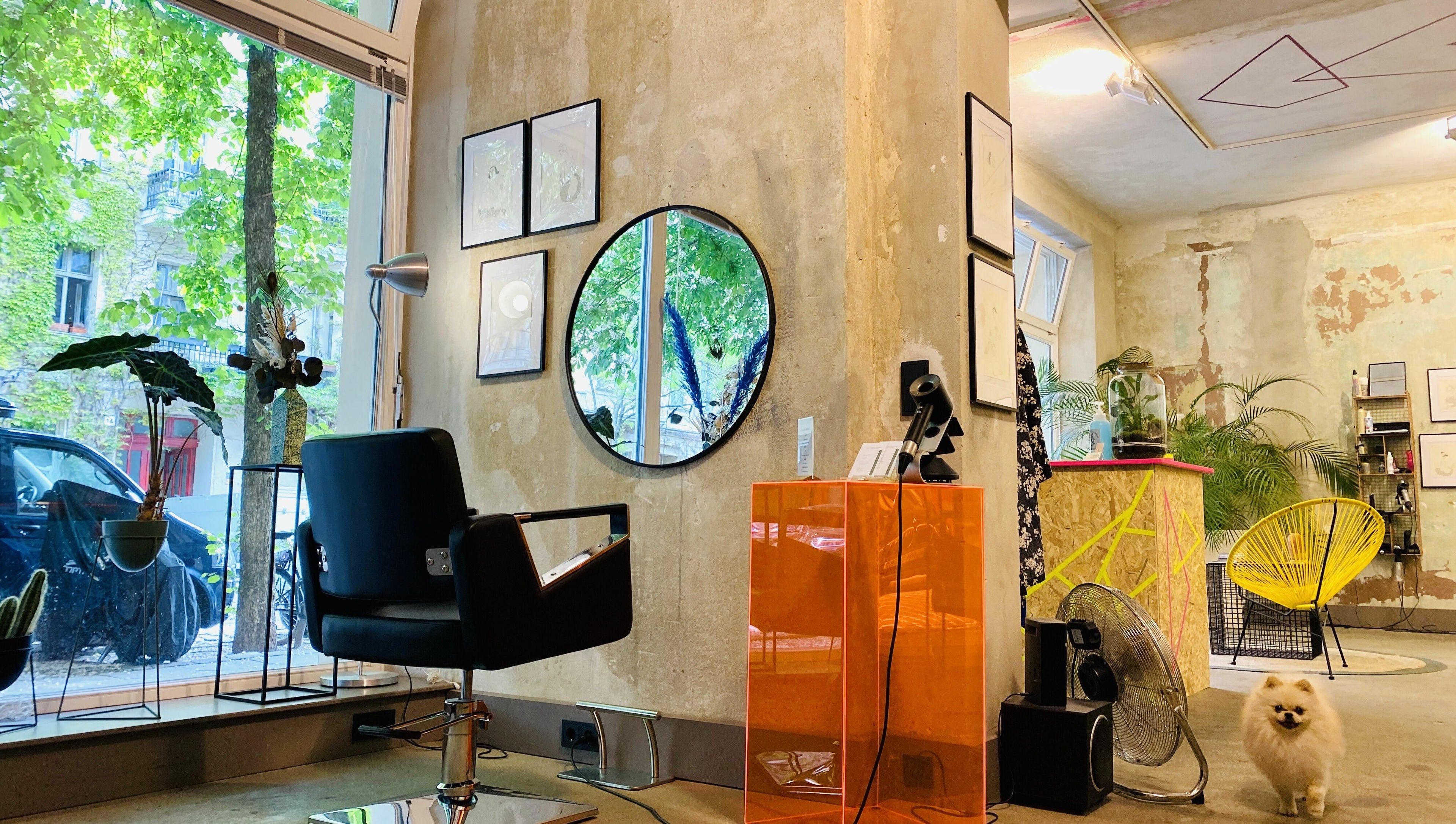 Inside Marc-Antoine Hairstudio Gallery, Berlin, Berlin, DE. Stylish chair facing mirror with lush green views.